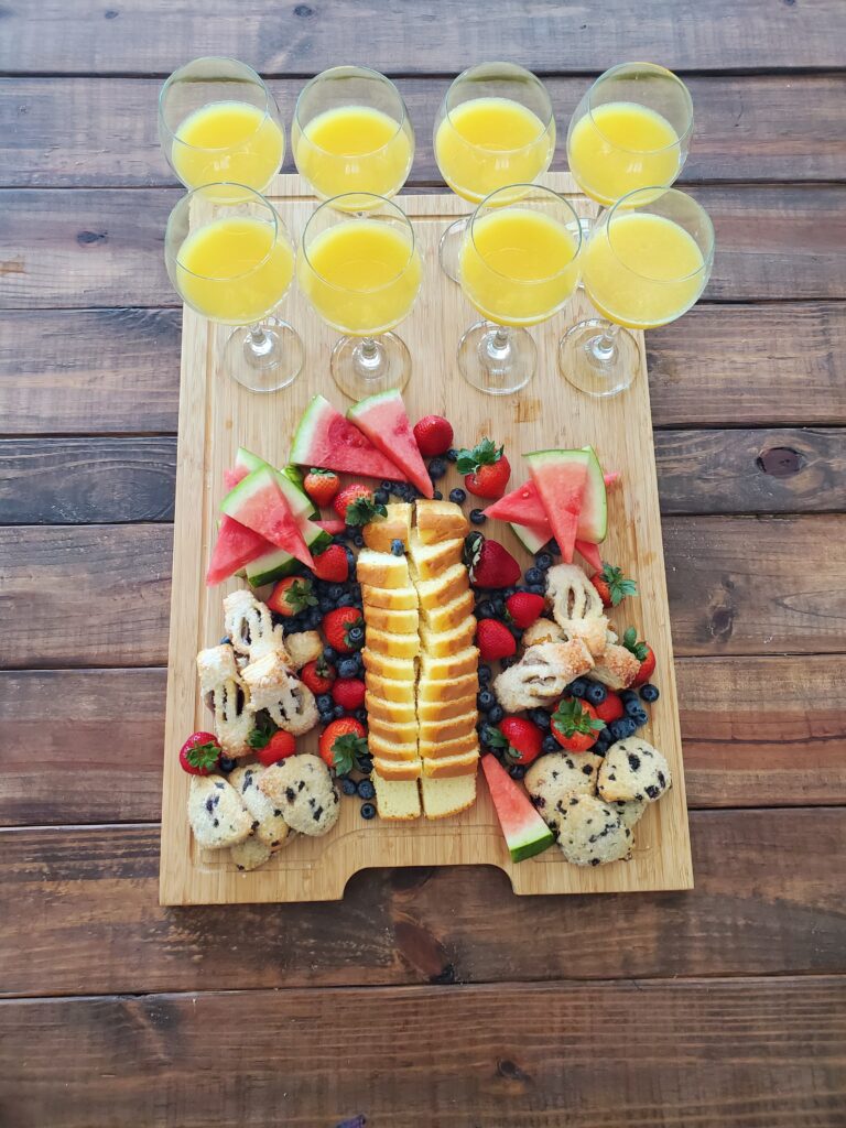 Fruit and pastry platter with orange juice.