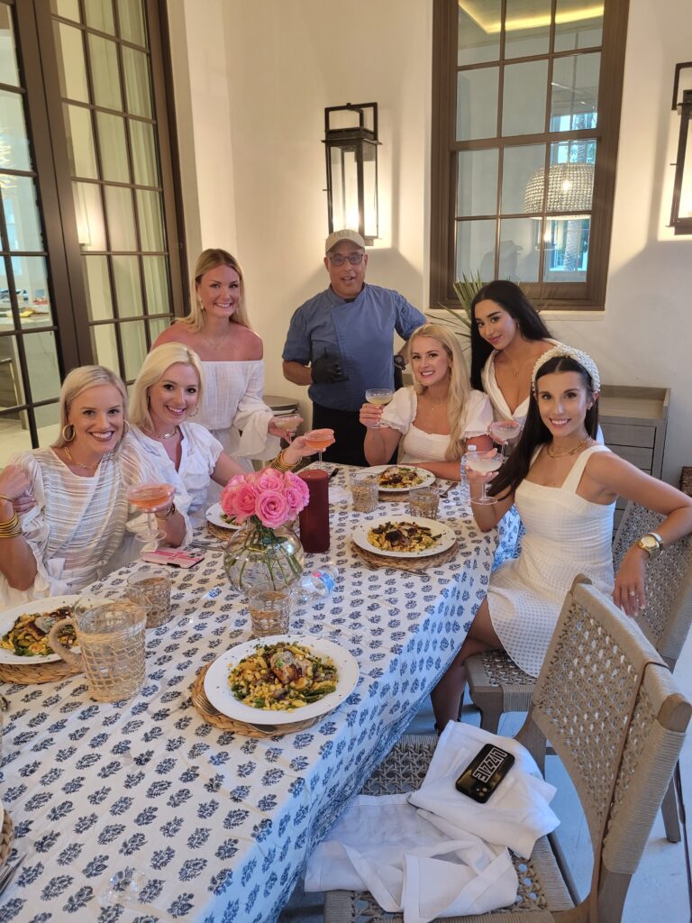Group of women dining outdoors with drinks.