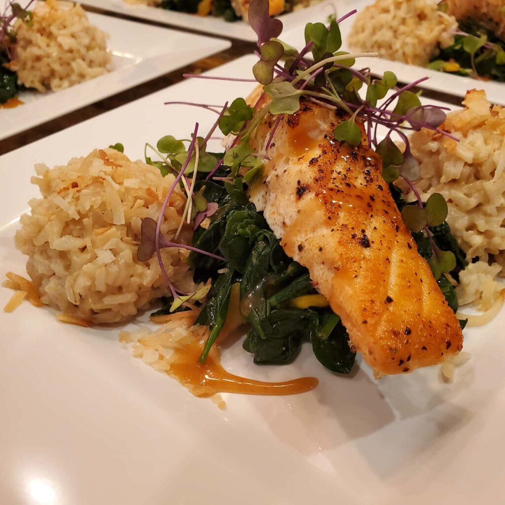 A plate of food with rice and greens on it.