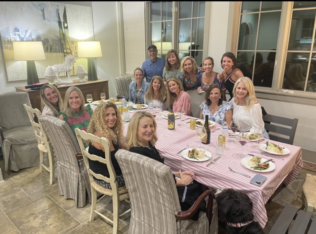 A group of women sitting at a table with food.