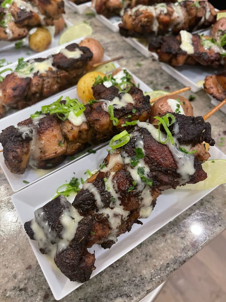 A table topped with plates of food covered in sauce.